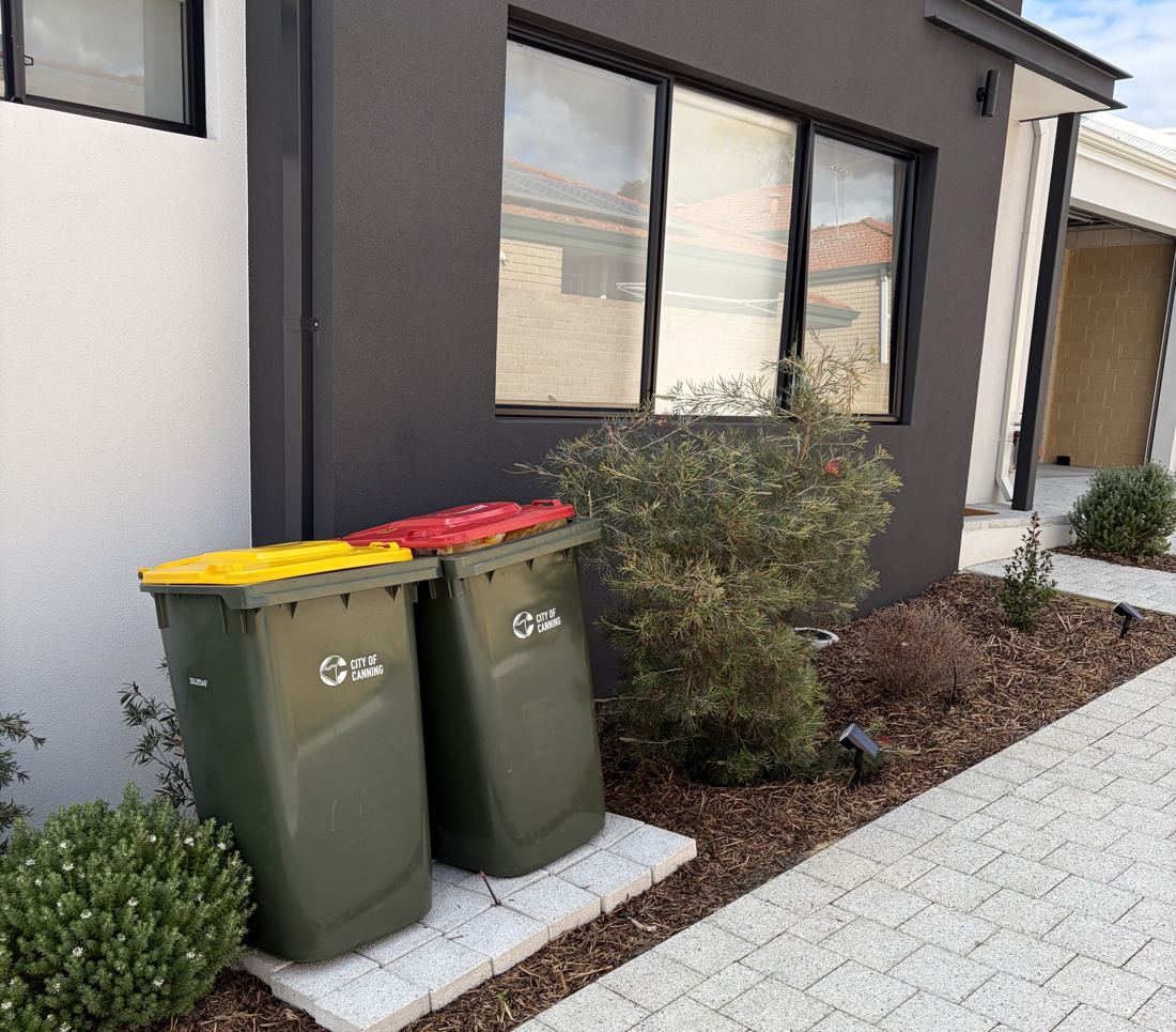 Recycling and general waste bins at the front of the house, under the living room window